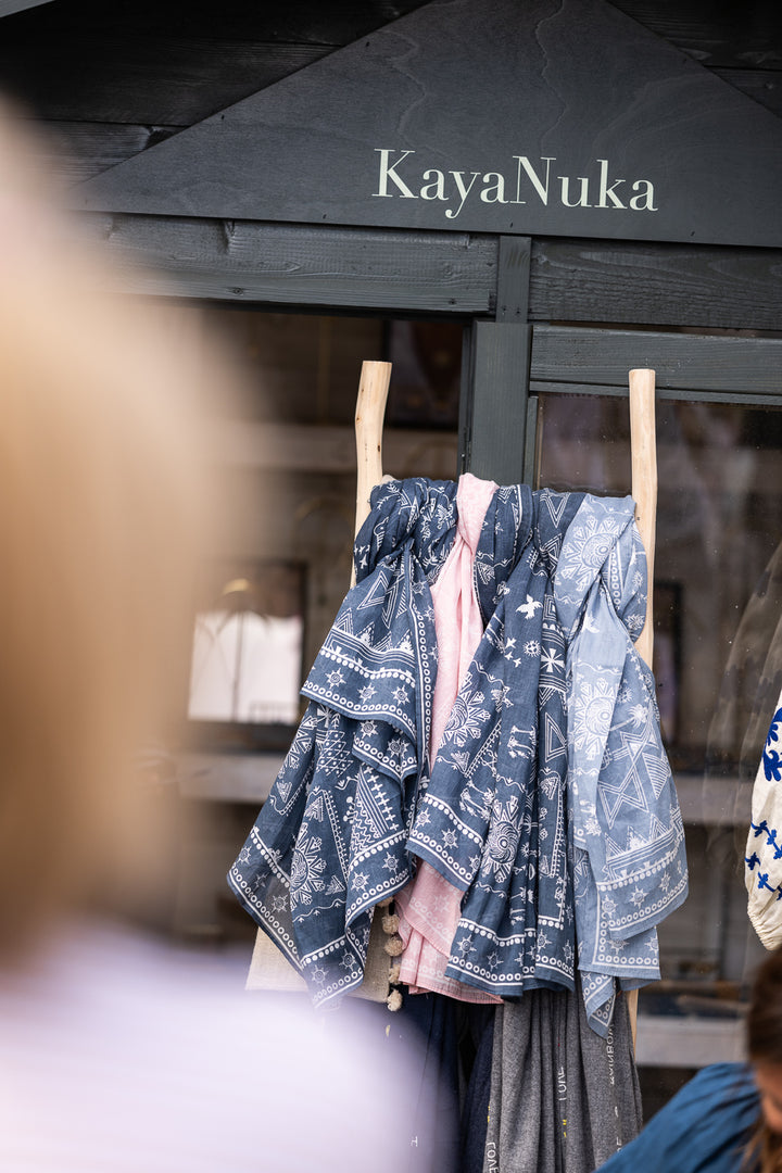 Blue patterned dress hanging on a rack under a &
