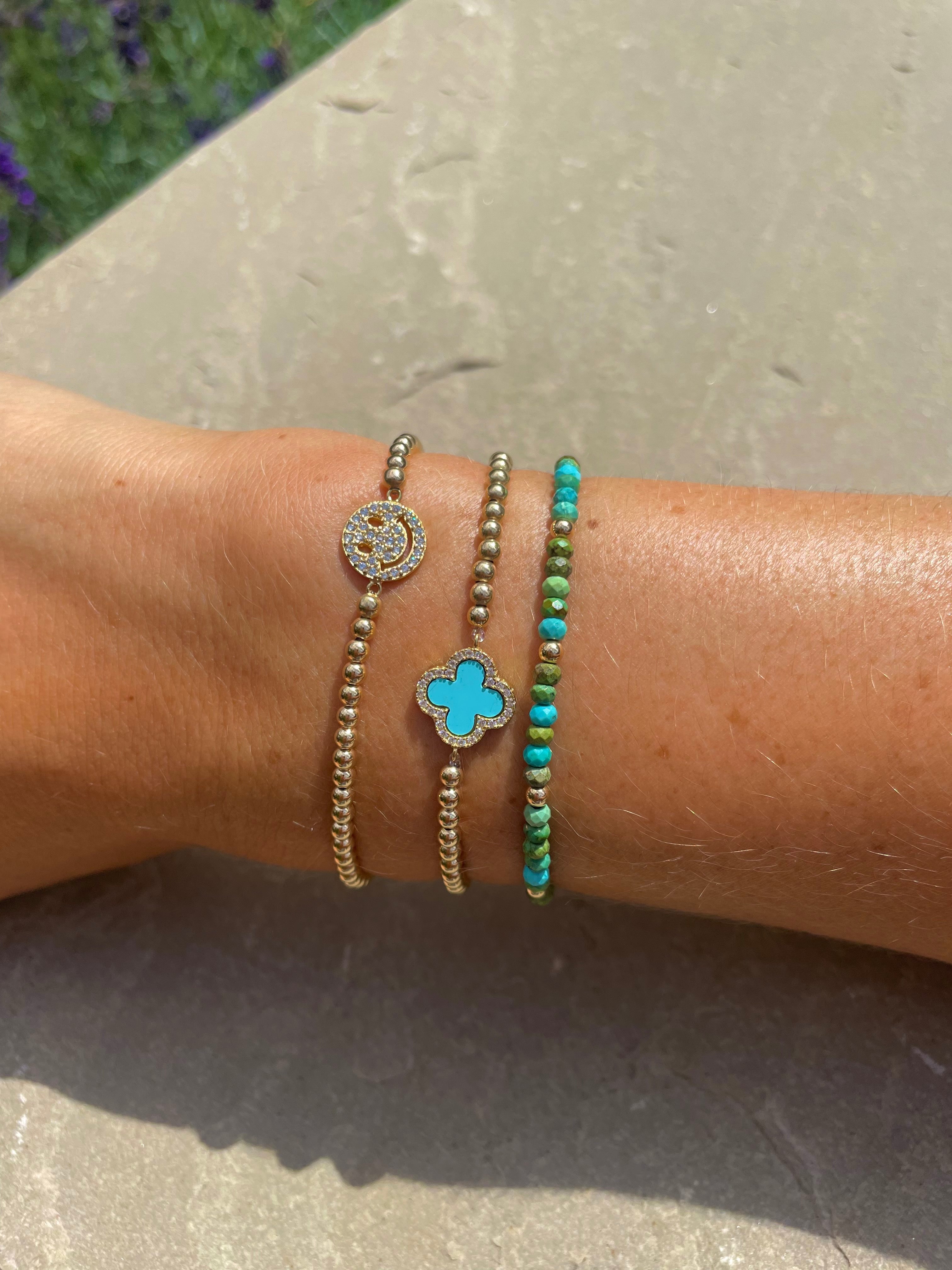 gold beaded bracelets with smiley face and turquoise clover pendant
