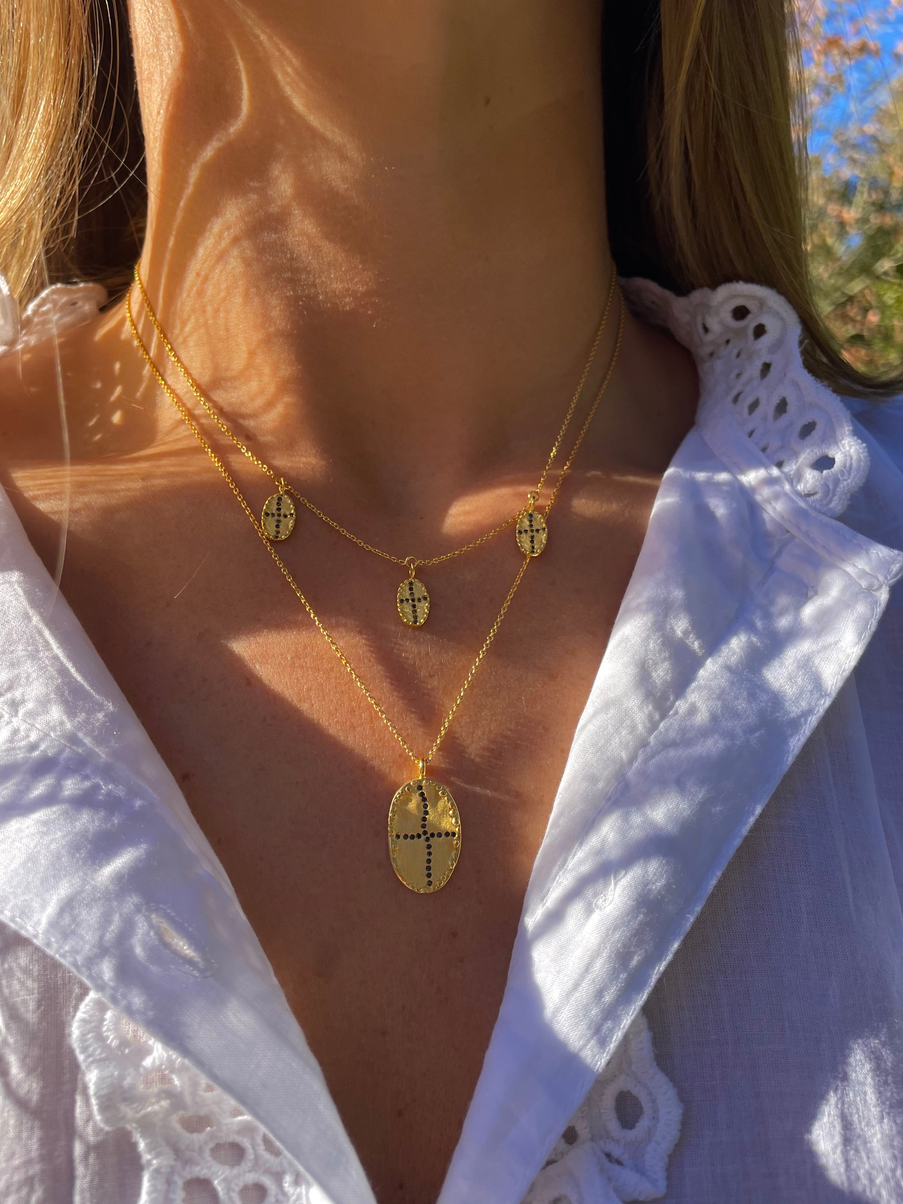 Gold plated long and short necklace brushed and matte oval  black zircons shape of an irregular cross  Louise Hendricks. 